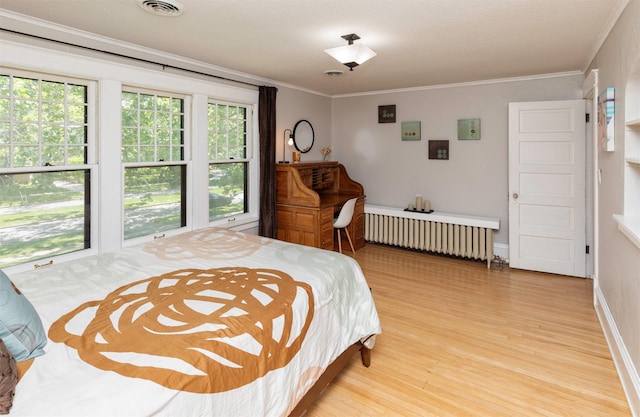 642 Polk Blvd, Des Moines, IA 50312 - bedroom featuring radiator, light wood finished floors, and crown molding