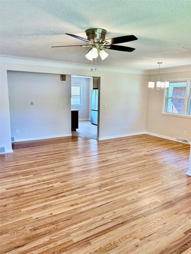 2327 Glenbrook Dr, Des Moines, IA 50316 - spare room featuring light wood-style flooring, a textured ceiling, ceiling fan, a chandelier, and ornamental molding