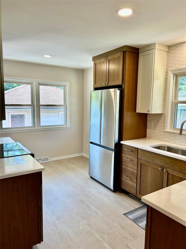 2327 Glenbrook Dr, Des Moines, IA 50316 - kitchen featuring freestanding refrigerator, light countertops, recessed lighting, tasteful backsplash, and light carpet