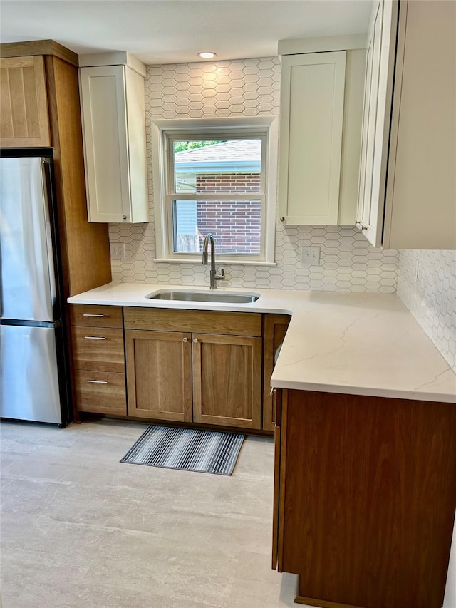 2327 Glenbrook Dr, Des Moines, IA 50316 - kitchen with freestanding refrigerator, backsplash, brown cabinets, and light stone counters