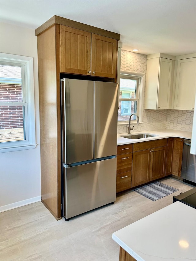 2327 Glenbrook Dr, Des Moines, IA 50316 - kitchen featuring freestanding refrigerator, light countertops, decorative backsplash, and brown cabinets