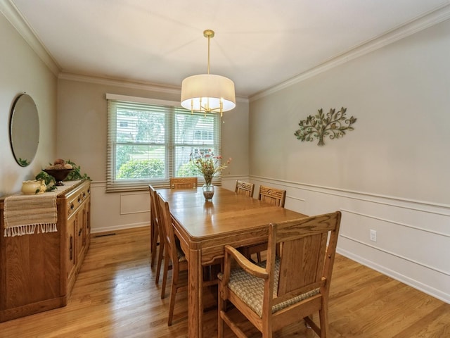 2906 Watrous Ave, Des Moines, IA 50321 - dining room featuring ornamental molding, light wood-type flooring, and a wainscoted wall