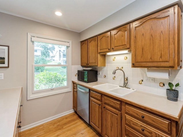 2906 Watrous Ave, Des Moines, IA 50321 - kitchen featuring stainless steel dishwasher, brown cabinetry, black microwave, backsplash, and light wood-style flooring