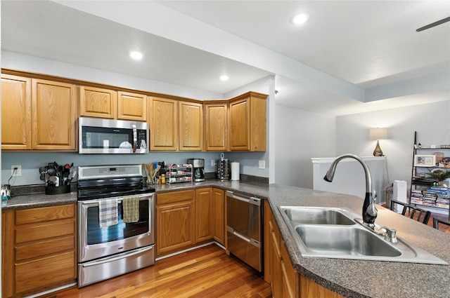 711 Kitterman Cir, Norwalk, IA 50211 - kitchen with stainless steel appliances, recessed lighting, light wood finished floors, and dark countertops