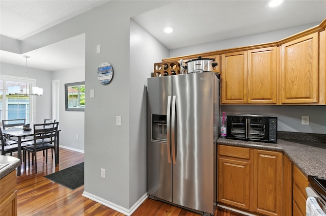 711 Kitterman Cir, Norwalk, IA 50211 - kitchen with stainless steel fridge, a chandelier, dark countertops, wood finished floors, and range