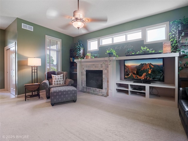 4710 76th St, Urbandale, IA 50322 - living area featuring carpet flooring, a tile fireplace, and a ceiling fan