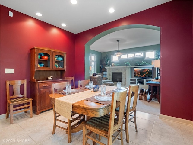 4710 76th St, Urbandale, IA 50322 - dining space featuring arched walkways, a fireplace, recessed lighting, a ceiling fan, and light tile patterned floors
