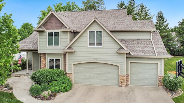 4710 76th St, Urbandale, IA 50322 - craftsman inspired home featuring roof with shingles, driveway, stone siding, and an attached garage