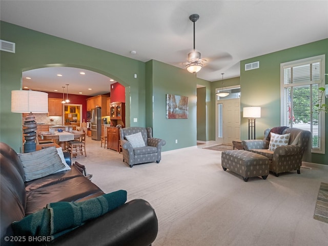 4710 76th St, Urbandale, IA 50322 - living room with arched walkways, light carpet, a ceiling fan, and recessed lighting
