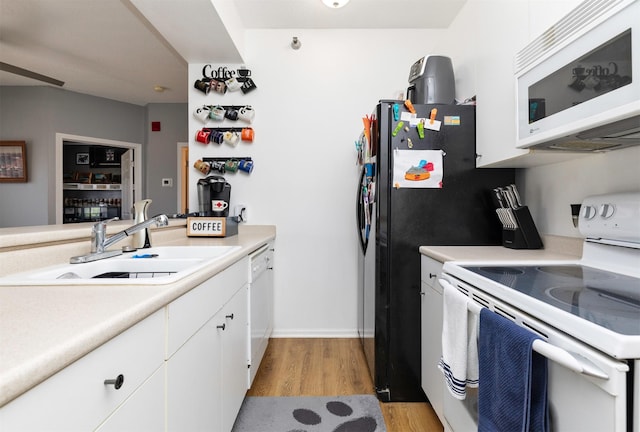 2323 E Porter Ave Unit 36, Des Moines, IA 50320 - kitchen featuring white appliances, light wood finished floors, light countertops, and white cabinetry