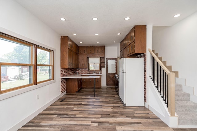 600 S 3rd Ave W, Newton, IA 50208 - kitchen featuring freestanding refrigerator, recessed lighting, a peninsula, wood finished floors, and light countertops