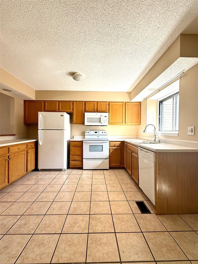 2519 W 1st St, Ankeny, IA 50023 - kitchen with white appliances, light countertops, a textured ceiling, brown cabinets, and light tile patterned floors