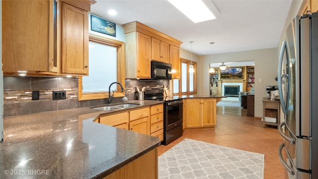 608 E 15th St N, Newton, IA 50208 - kitchen with black appliances, a peninsula, backsplash, hanging light fixtures, and light tile patterned floors