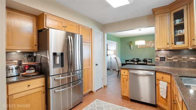 608 E 15th St N, Newton, IA 50208 - kitchen featuring stainless steel appliances, backsplash, light tile patterned floors, glass insert cabinets, and light brown cabinetry
