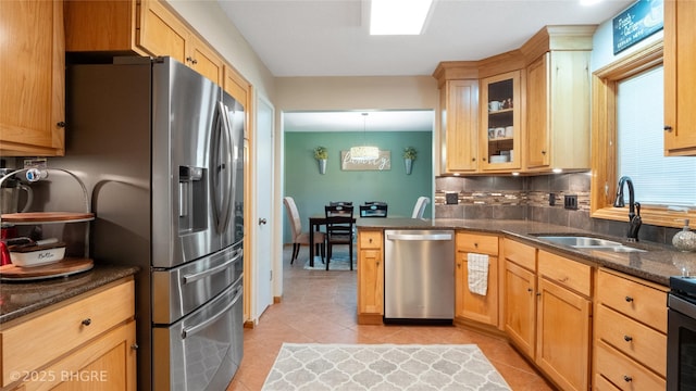 608 E 15th St N, Newton, IA 50208 - kitchen featuring appliances with stainless steel finishes, light tile patterned floors, backsplash, dark stone countertops, and glass insert cabinets