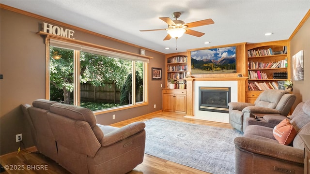 608 E 15th St N, Newton, IA 50208 - living room featuring ceiling fan, a fireplace with flush hearth, wood finished floors, crown molding, and recessed lighting