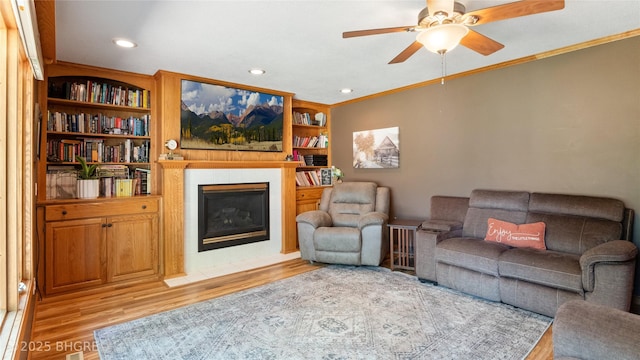 608 E 15th St N, Newton, IA 50208 - living room with light wood-style floors, crown molding, a ceiling fan, a tiled fireplace, and recessed lighting