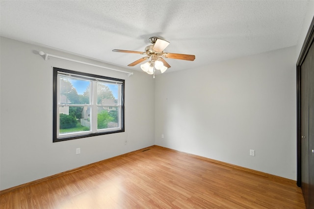 1228 64th St, West Des Moines, IA 50266 - empty room featuring light wood-style flooring, a textured ceiling, and ceiling fan