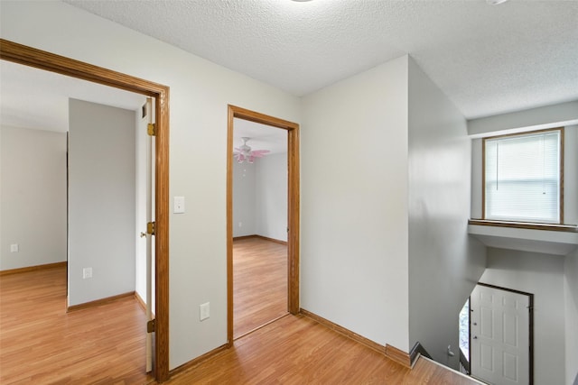 1228 64th St, West Des Moines, IA 50266 - hallway featuring light wood-type flooring and a textured ceiling
