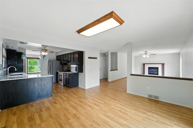 1228 64th St, West Des Moines, IA 50266 - unfurnished living room with ceiling fan, light wood-style flooring, and a glass covered fireplace