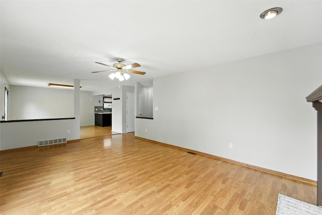 1228 64th St, West Des Moines, IA 50266 - unfurnished living room with light wood finished floors and ceiling fan