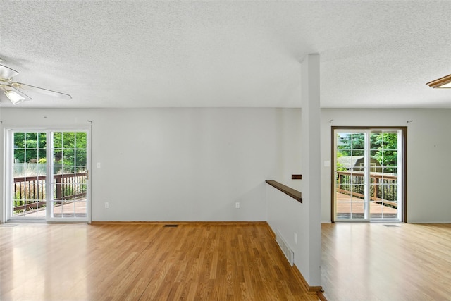 1228 64th St, West Des Moines, IA 50266 - spare room featuring a textured ceiling, ceiling fan, wood finished floors, and healthy amount of natural light