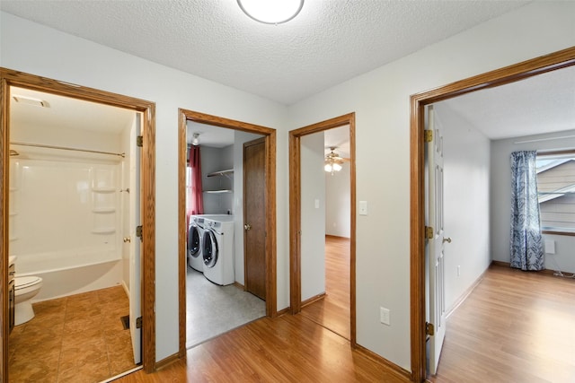 1228 64th St, West Des Moines, IA 50266 - hallway featuring washer and clothes dryer, light wood finished floors, and a textured ceiling