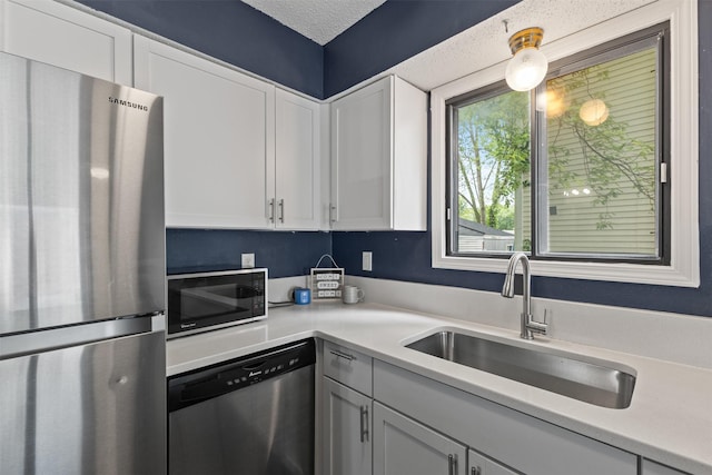 1913 E Bell Ave, Des Moines, IA 50320 - kitchen with stainless steel appliances, light countertops, and white cabinetry
