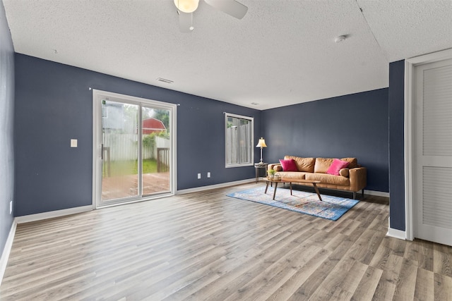 1913 E Bell Ave, Des Moines, IA 50320 - living room with a textured ceiling, wood finished floors, and a ceiling fan