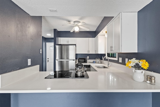 1913 E Bell Ave, Des Moines, IA 50320 - kitchen featuring black appliances, ceiling fan, white cabinetry, a textured ceiling, and a peninsula