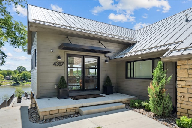 4387 Panorama Dr, Panora, IA 50216 - view of exterior entry featuring a standing seam roof, a metal roof, and a water view