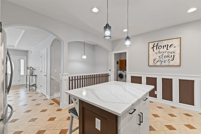 4315 129th St, Urbandale, IA 50323 - kitchen with washer / dryer, fridge, recessed lighting, hanging light fixtures, and a kitchen island