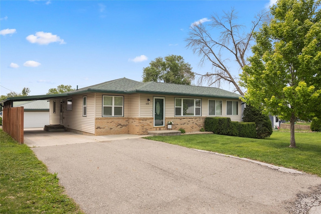408 Cherry Ave, Woodward, IA 50276 - single story home with brick siding, an outbuilding, a front lawn, asphalt driveway, and a garage