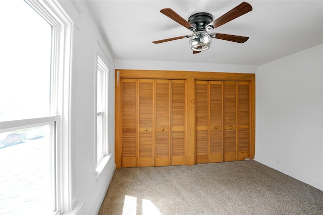 403 E 2nd St S, Newton, IA 50208 - unfurnished bedroom with carpet floors, multiple closets, multiple windows, and ceiling fan