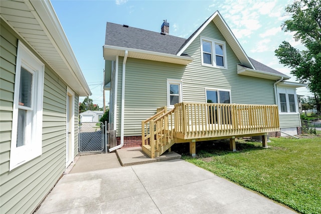 403 E 2nd St S, Newton, IA 50208 - back of house featuring roof with shingles, a gate, a lawn, a wooden deck, and a patio area