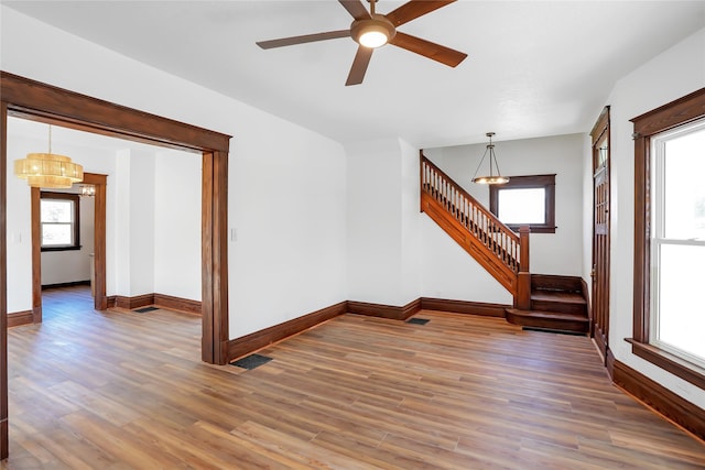 403 E 2nd St S, Newton, IA 50208 - empty room with stairs, a chandelier, wood finished floors, and ceiling fan