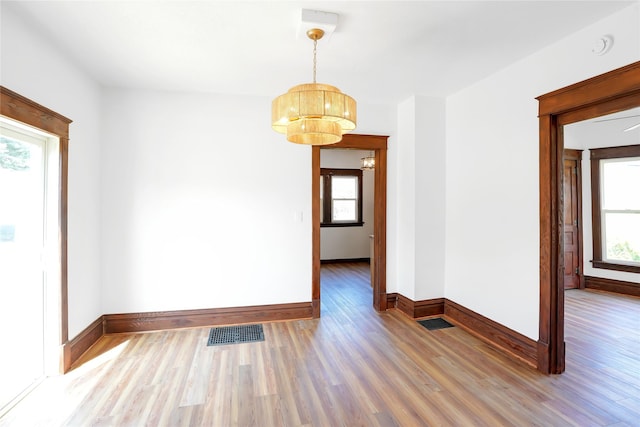 403 E 2nd St S, Newton, IA 50208 - unfurnished dining area with wood finished floors, healthy amount of natural light, and a chandelier