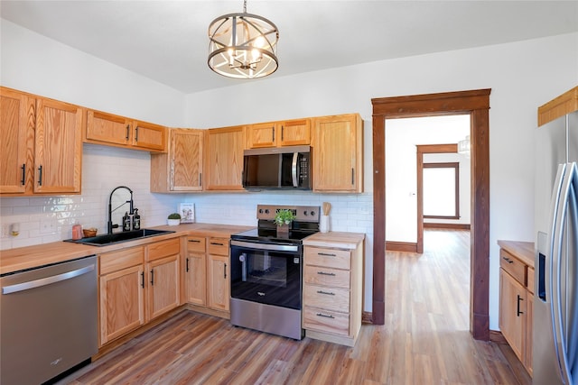 403 E 2nd St S, Newton, IA 50208 - kitchen with stainless steel appliances, a chandelier, backsplash, and light wood finished floors