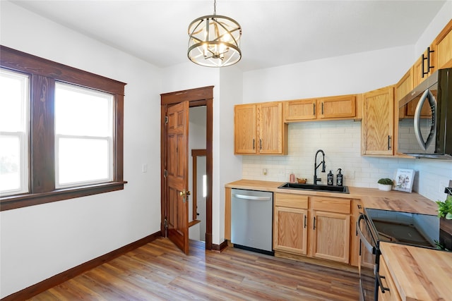 403 E 2nd St S, Newton, IA 50208 - kitchen with appliances with stainless steel finishes, wooden counters, decorative backsplash, a chandelier, and light wood-style flooring