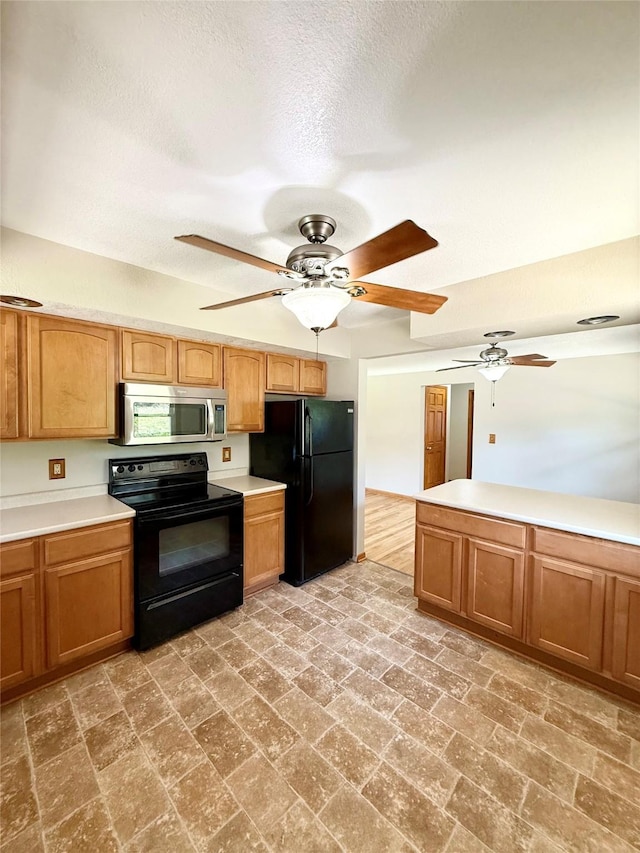 3355 Kinsey Ave, Des Moines, IA 50317 - kitchen featuring black appliances, a ceiling fan, light countertops, a textured ceiling, and brick patterned floors