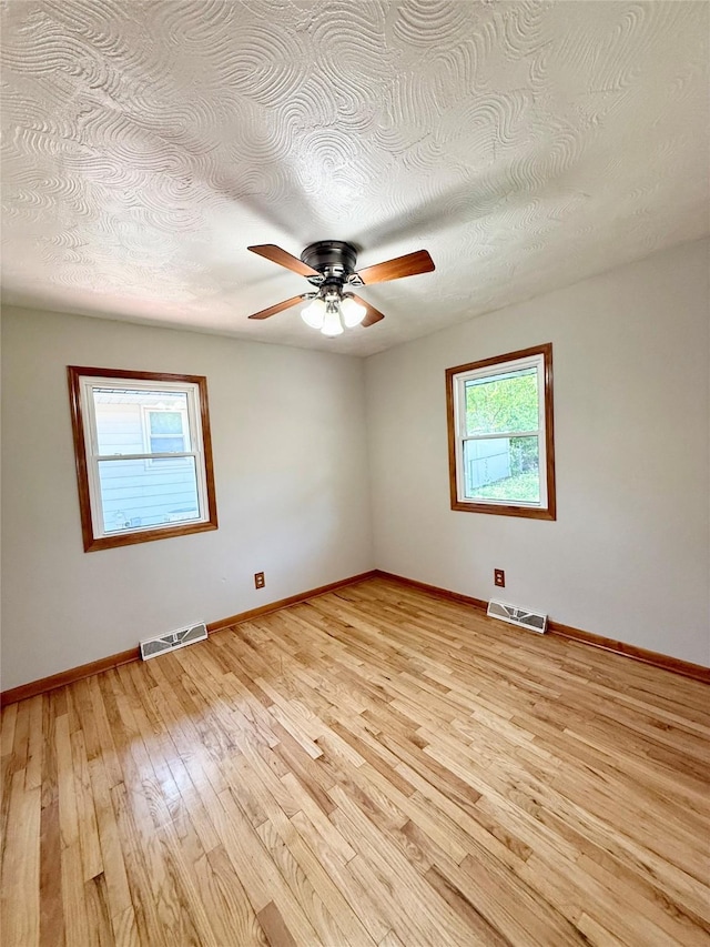 3355 Kinsey Ave, Des Moines, IA 50317 - empty room featuring light wood-type flooring, ceiling fan, and a textured ceiling