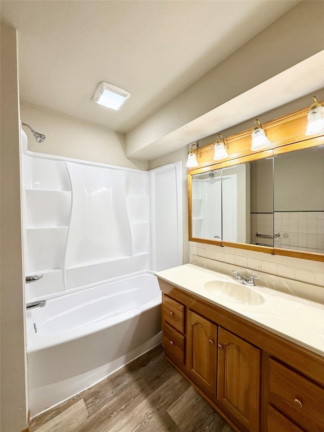 3355 Kinsey Ave, Des Moines, IA 50317 - bathroom with wood finished floors, backsplash, vanity, and shower / bathtub combination
