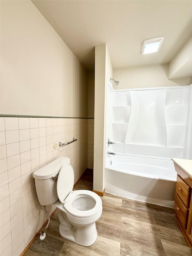 3355 Kinsey Ave, Des Moines, IA 50317 - full bath featuring tile walls, wood finished floors, shower / bath combination, vanity, and a wainscoted wall