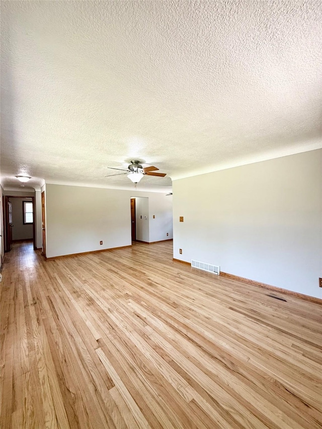 3355 Kinsey Ave, Des Moines, IA 50317 - unfurnished living room featuring a textured ceiling, light wood-style flooring, and ceiling fan