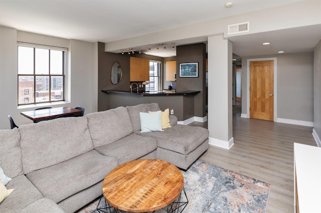 400 Walnut St Unit 901, Des Moines, IA 50309 - living room featuring rail lighting, wood finished floors, and plenty of natural light