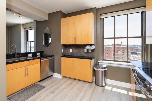 400 Walnut St Unit 901, Des Moines, IA 50309 - kitchen featuring stainless steel appliances, light wood-type flooring, decorative backsplash, and dark countertops
