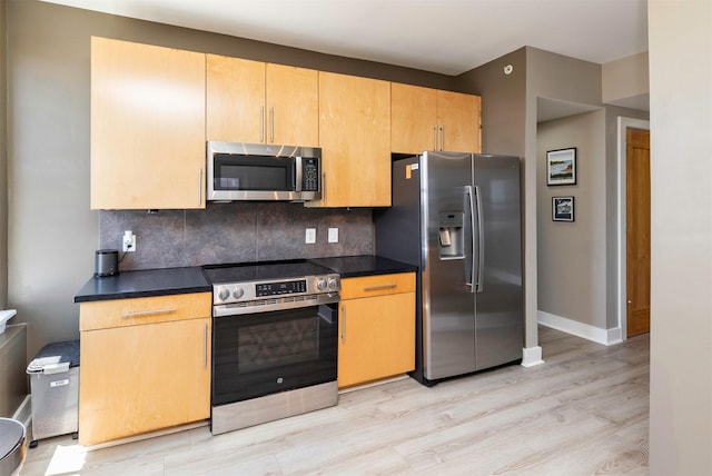 400 Walnut St Unit 901, Des Moines, IA 50309 - kitchen with appliances with stainless steel finishes, light wood-style floors, backsplash, and dark countertops