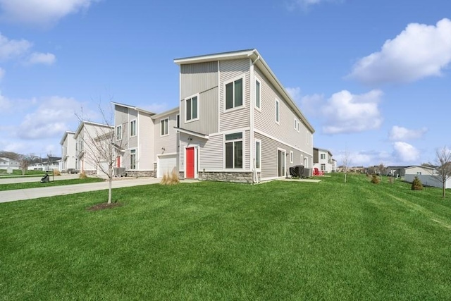 9529 Capstone Ct, West Des Moines, IA 50266 - back of property featuring concrete driveway, a yard, and stone siding
