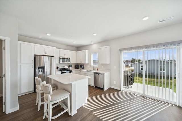 9529 Capstone Ct, West Des Moines, IA 50266 - kitchen with stainless steel appliances, dark wood-style floors, a kitchen island, white cabinets, and light countertops
