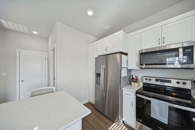 9529 Capstone Ct, West Des Moines, IA 50266 - kitchen with appliances with stainless steel finishes, dark wood finished floors, white cabinets, recessed lighting, and light stone countertops